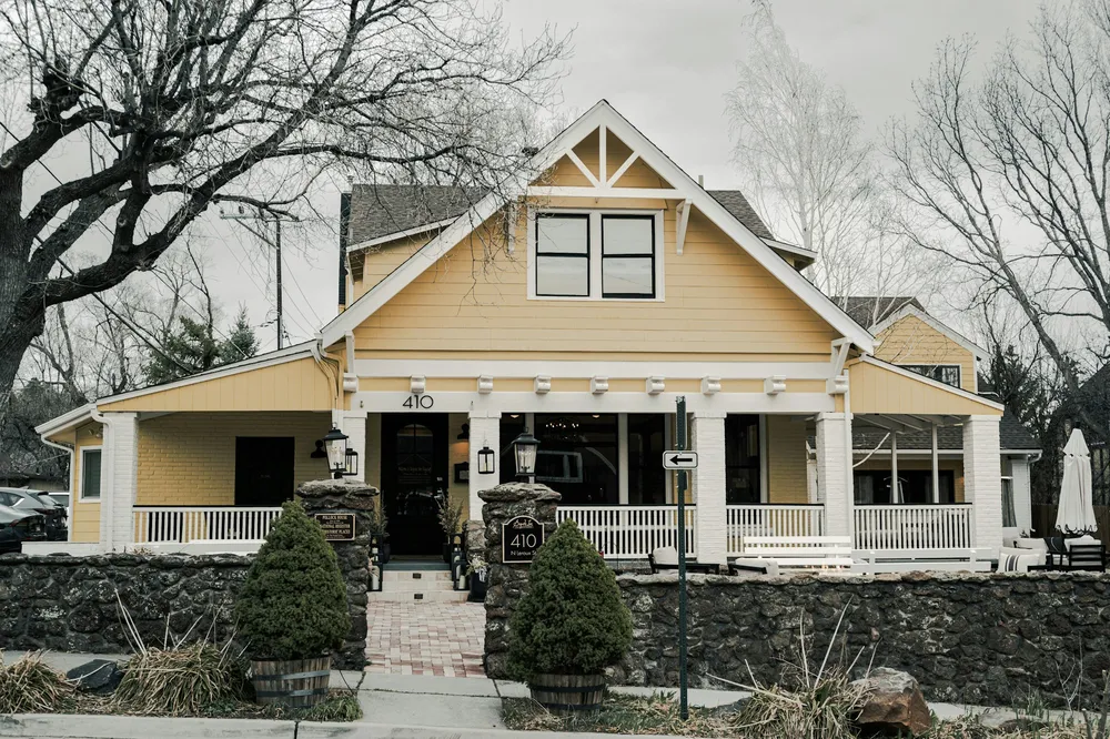 A yellow craftsman house with a wide front porch