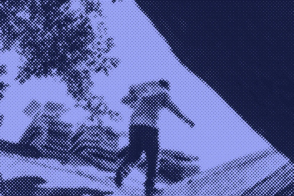 A roofer carrying shingles across a roof